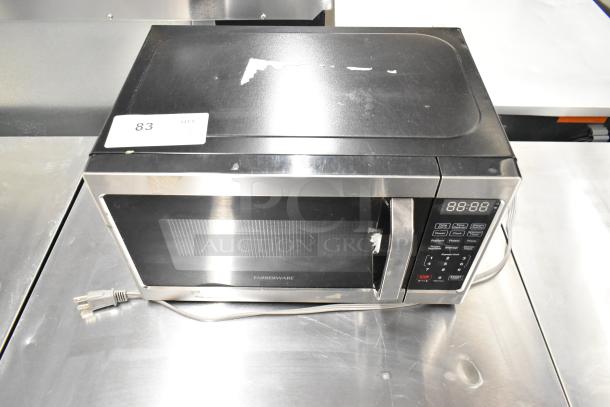 2022 Farberware FMO07AHTBKJ metal countertop microwave oven, 120 volts, visible wear, item tag "83" on top, with plug.