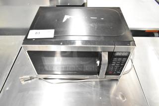 2022 Farberware FMO07AHTBKJ metal countertop microwave oven, 120 volts, visible wear, item tag "83" on top, with plug.