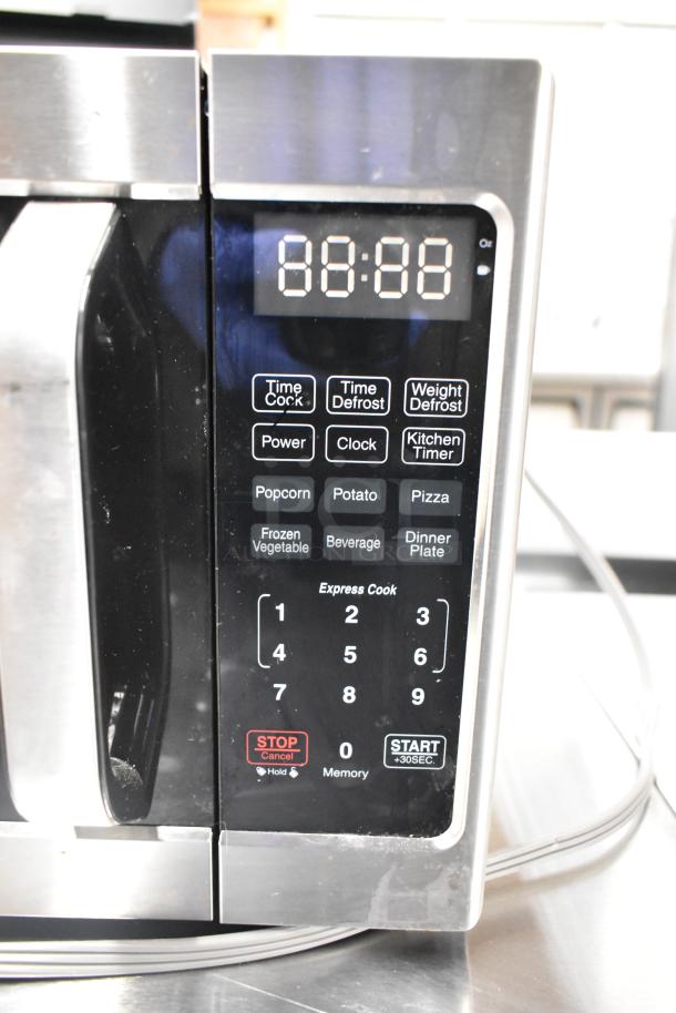 2022 Farberware FMO07AHTBKJ metal countertop microwave oven, digital display, various preset buttons, 120 volts, like new condition.