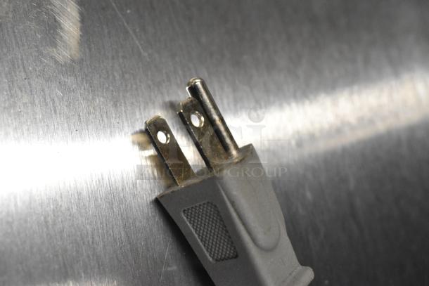 Close-up of a Farberware microwave power plug against a metal surface. Model FMO07AHTBKJ, 120 volts, 1 phase.