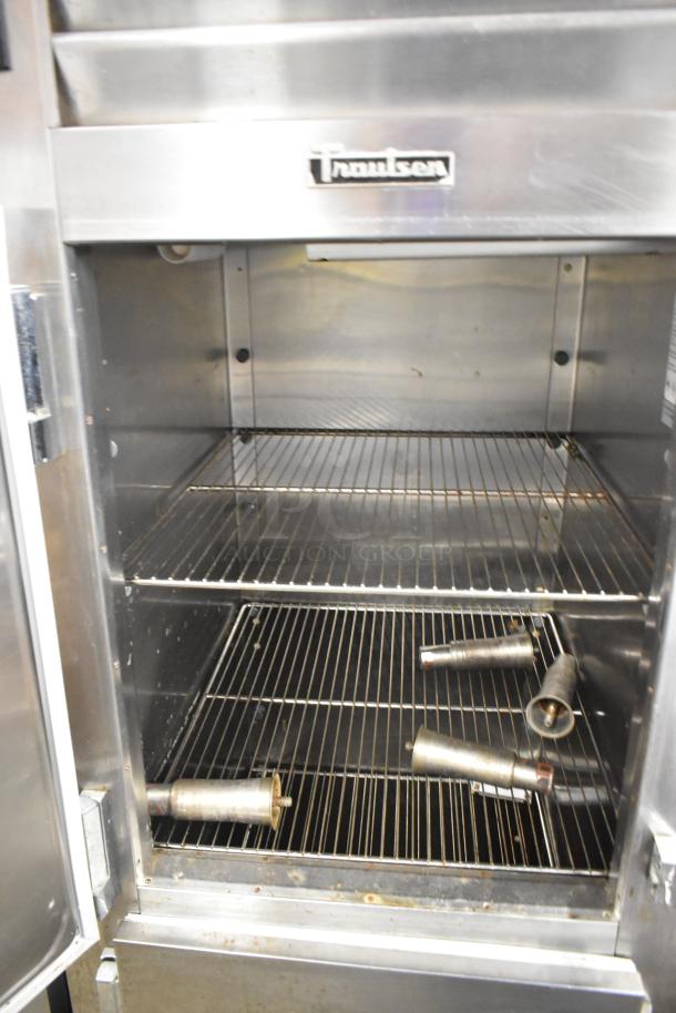 Traulsen stainless steel commercial reach-in cooler with two half-size doors and metal racks. Model for 115 volts, 1 phase.