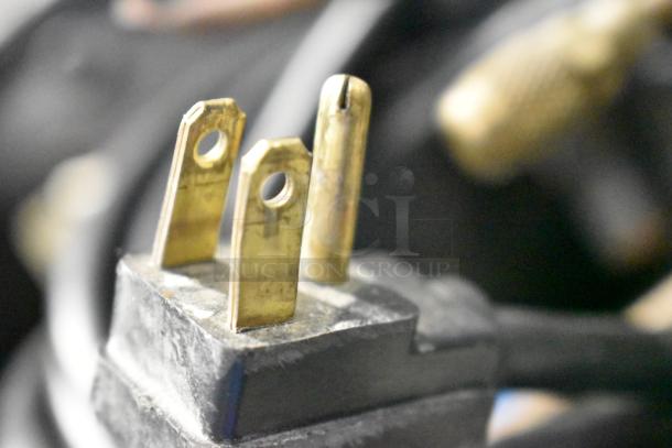 Close-up of the power plug for a Traulsen G12010 Commercial Freezer, showing brass prongs.