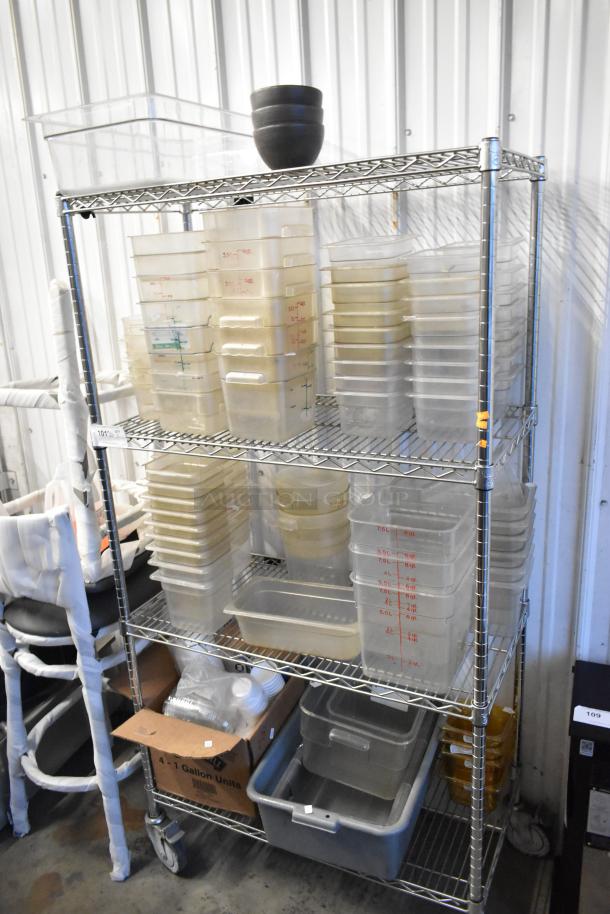 Lot of various poly drop-in bins and containers on a shelving unit. Includes diverse sizes and types. Shelving not included.