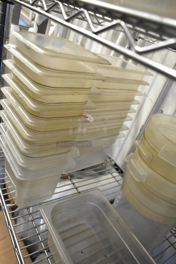 Lot of poly drop-in bins and containers, varying sizes, stacked on metal shelf. Visible sticker on one bin. Good condition. Shelving not included.