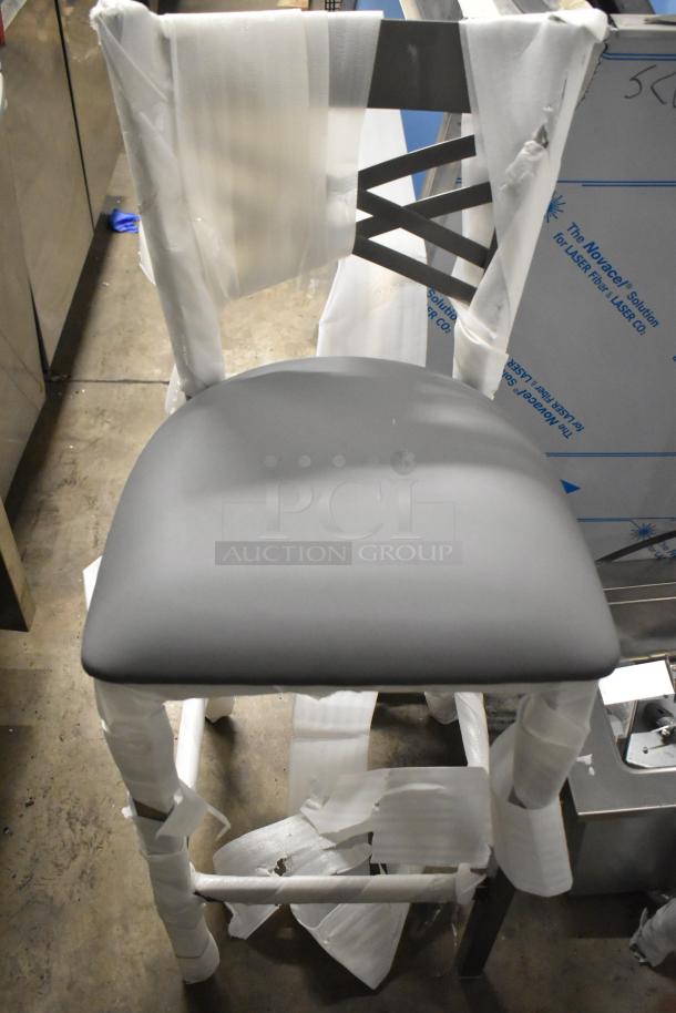 Brand new Lancaster Table & Seating bar height chair in gray, metal crossback design, packaging present, slight scratch and dent.