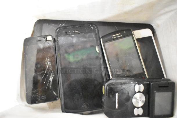 Basket containing 22 assorted electronics, including smartphones and a tablet; some items show screen damage.