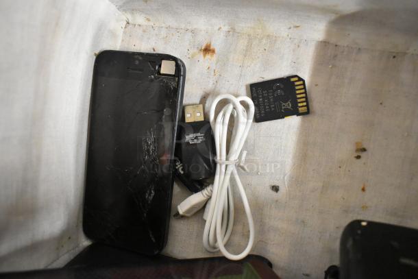 Damaged smartphone, USB cable, and Toshiba SD card in a basket. Various items included. Auction for 22 items.