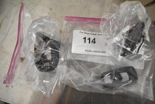 Plastic bags containing a BMW key fob, a watch, and a knob; auction lot 114, tagged with "PCIauctions.com".