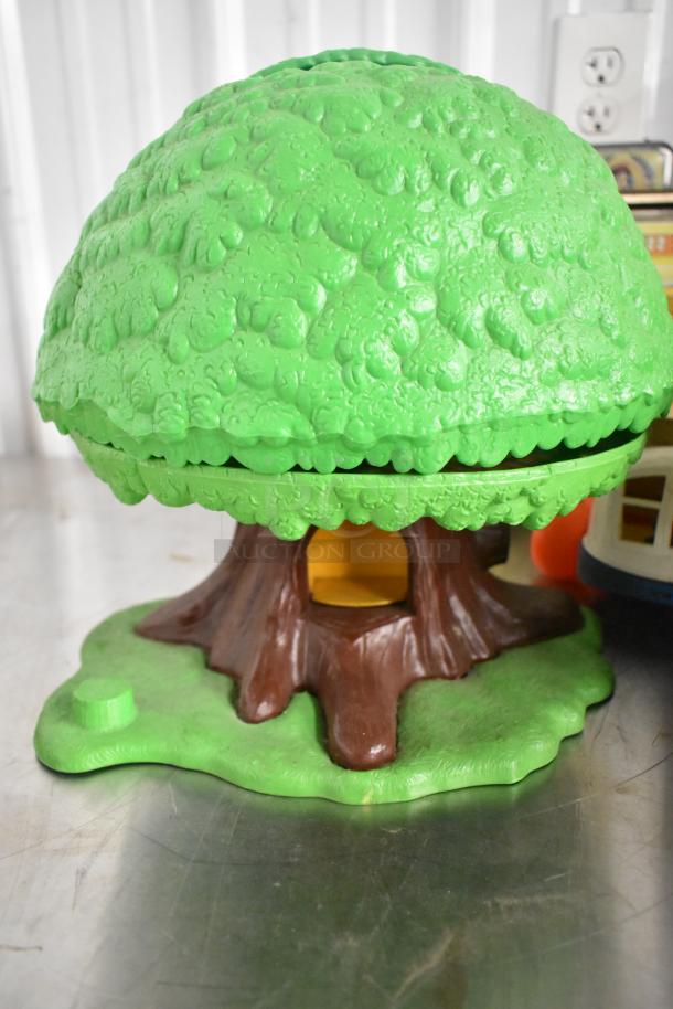 Green toy tree with textured foliage and brown trunk, part of a lot including Fisher Price shoe and Mufasa Funko Pop.