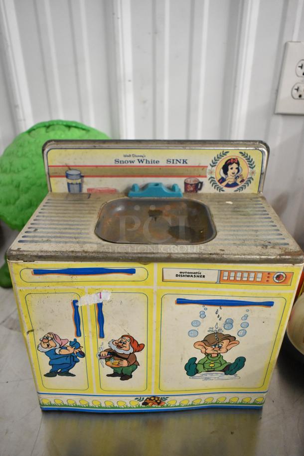 Vintage Disney Snow White toy sink with rust and illustrations of dwarfs, labeled "automatic dishwasher."