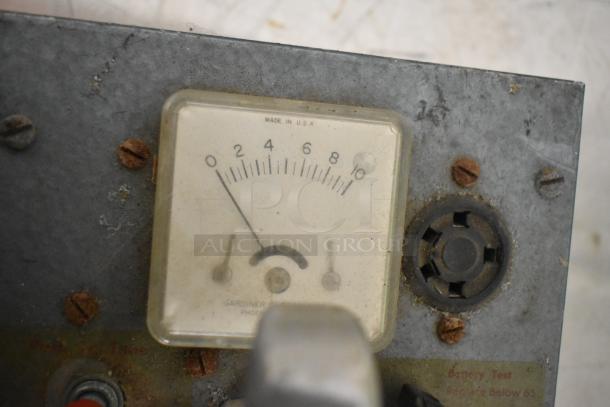 Vintage metal panel with a Gardiner voltmeter, showing 0-10 scale. Marked "Made in U.S.A." and slightly rusted screws.