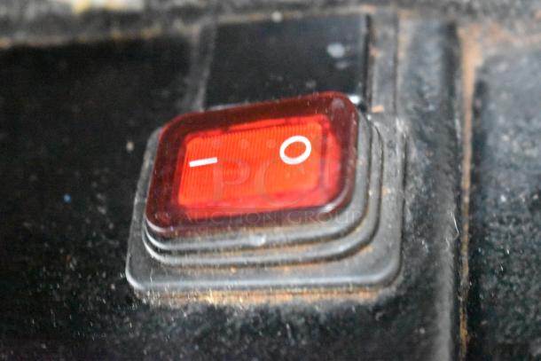 Close-up of the 2022 Hemro KR1203 coffee grinder's red power switch, showing on/off symbols.
