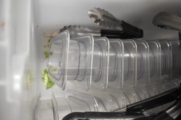 Lot of various items including stack of clear poly bins and metal utensils, stored in a white container. Visible wear.