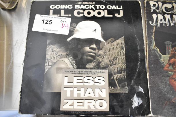 Three items including LL Cool J's "Going Back to Cali" record, Rick James record, and KIT-32A-BKA Belt Slide Kit; minor wear visible.