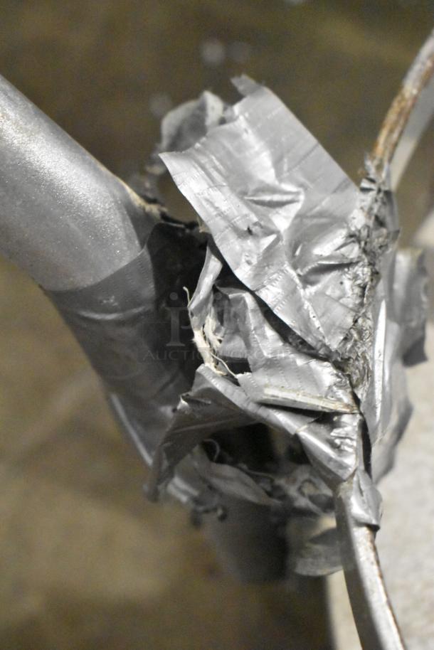 Metal Bowl Dolly with commercial casters, showing a repaired section with duct tape around a metal support joint, indicating use and wear.