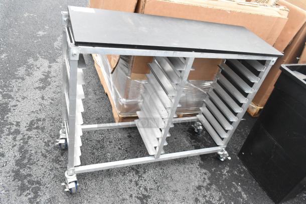 Metal double pan transport rack with commercial casters, featuring side slots for pans and sturdy construction.