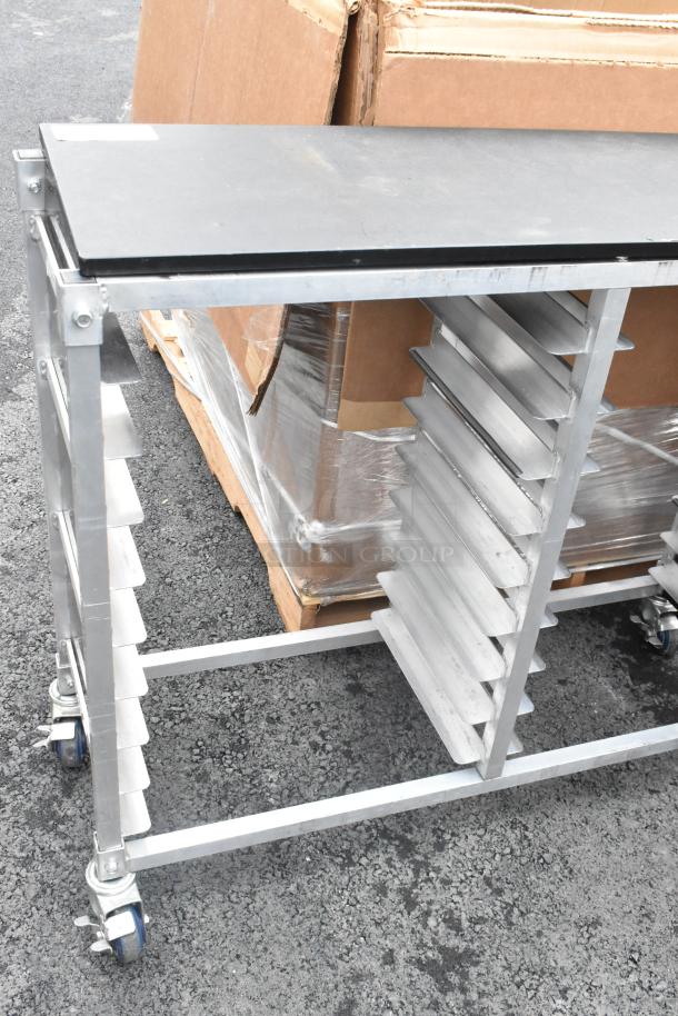 Metal double pan transport rack with commercial casters, featuring multiple shelves. Used condition, sturdy design.