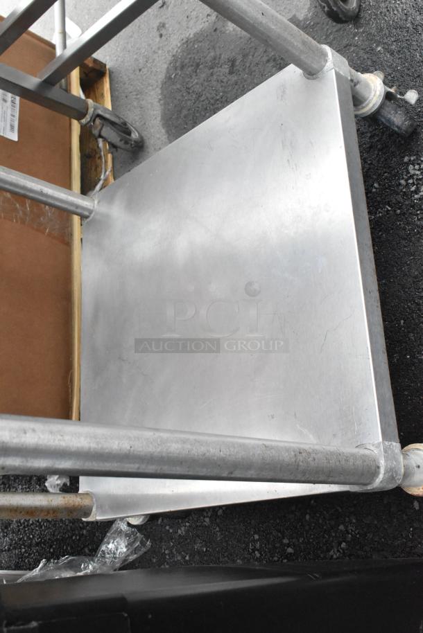 Stainless steel commercial table with metal under shelf, on robust commercial casters. Ideal for kitchen or workspace.