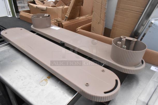 Eight light brown industrial units with mounting bases, slightly worn, placed on a metal table, surrounded by cardboard boxes.