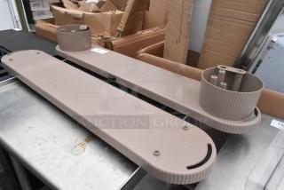 Eight light brown industrial units with mounting bases, slightly worn, placed on a metal table, surrounded by cardboard boxes.