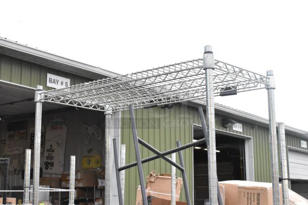 Chrome finish 4-tier wire shelving unit outdoors, sturdy design, minor wear. Buyer must dismantle for shipping.