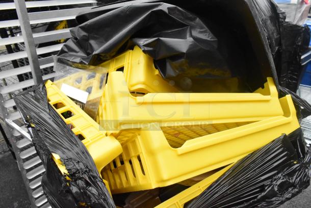 Poly trash can filled with yellow bread caddies, partially covered by a black plastic liner, showing signs of use.