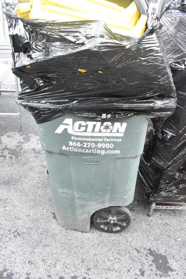 Poly trash can with attached lid, containing yellow bread caddies. Marked "Action Environmental Services" with contact info.