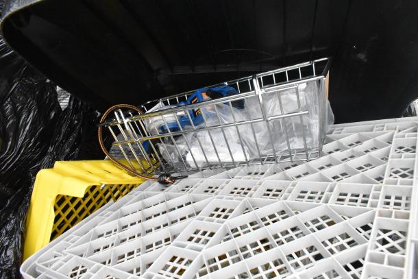 Rubbermaid gray poly trash can with contents, including yellow and gray caddies, under a black lid.