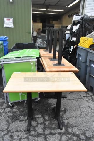 Six wood-pattern dining tables with black metal straight-leg bases, displayed outdoors.