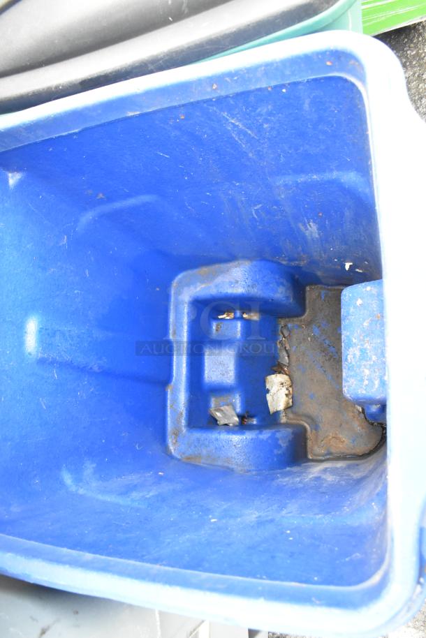 2 blue poly trash cans with hinge lids, visible wear and some debris inside, auction offers twice your bid.