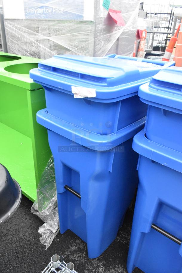 Two blue poly trash cans with hinged lids, excellent condition, note indicating "2 Times Your Bid" visible on side.