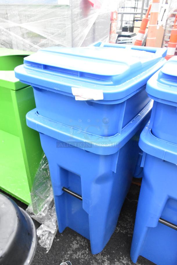 Two blue poly trash cans with hinge lids, auction item, new condition, includes label.