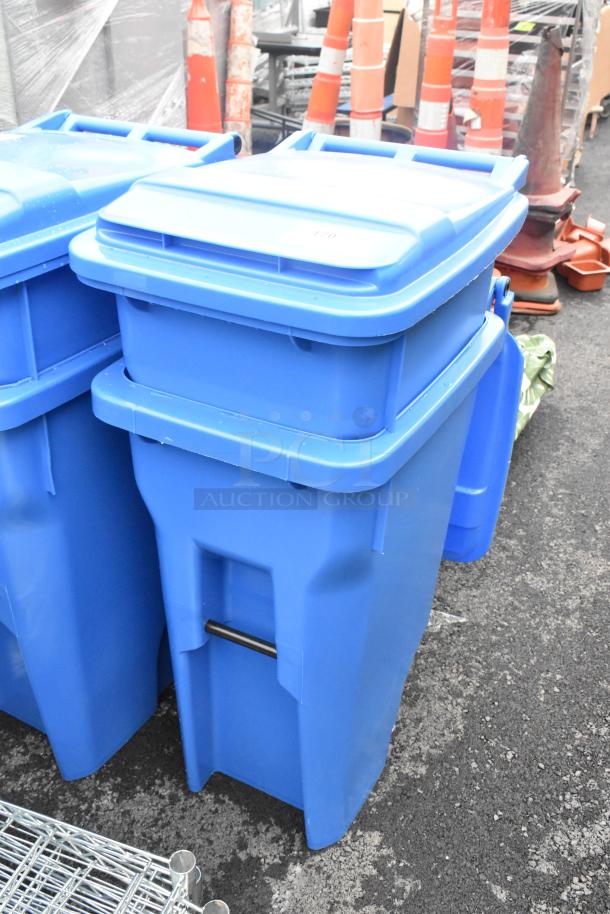Two blue poly trash cans with hinged lids, in good condition. Auction offers double your bid.