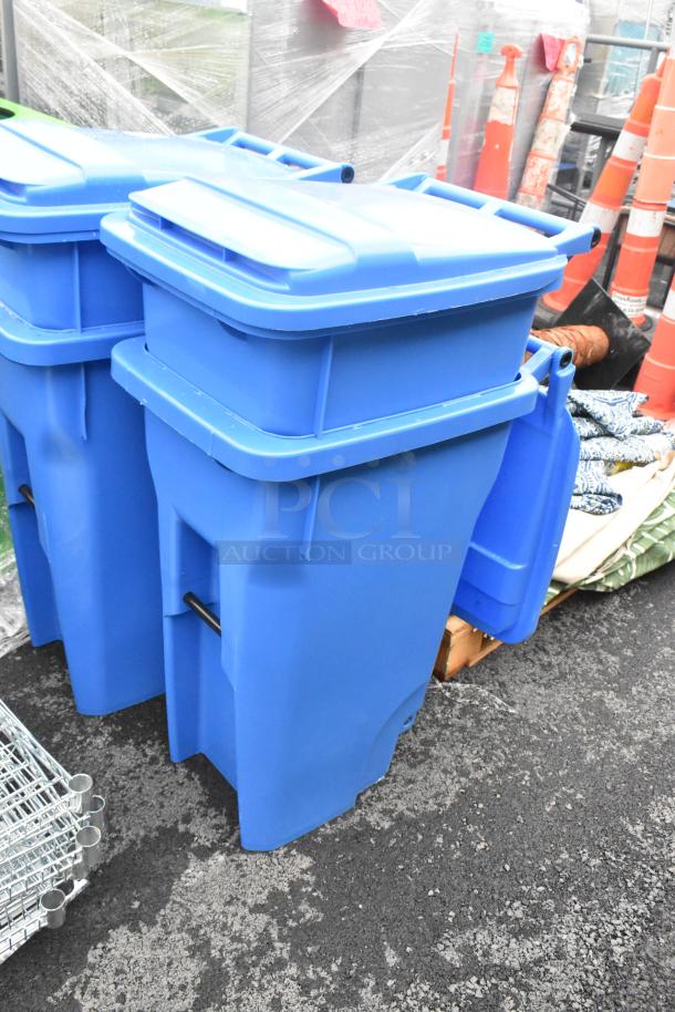 Two blue poly trash cans with hinge lids in good condition, ideal for outdoor waste management, available as a pair.