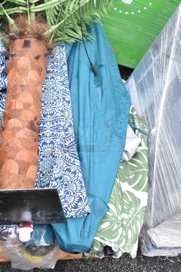 Assorted patio umbrellas, various colors and patterns, light wear, bundled together. Includes cables and other outdoor items.