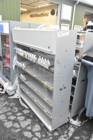 Two gray metal shelving units, adjustable shelves, used condition, with a tag marked "Used Assets." Appealing for storage needs.