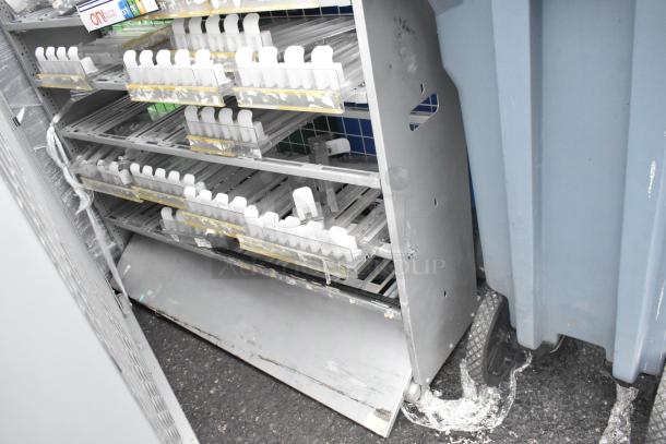 Two gray metal shelving units with multiple adjustable rows, showing signs of wear. Enclosed plastic organizers are included.