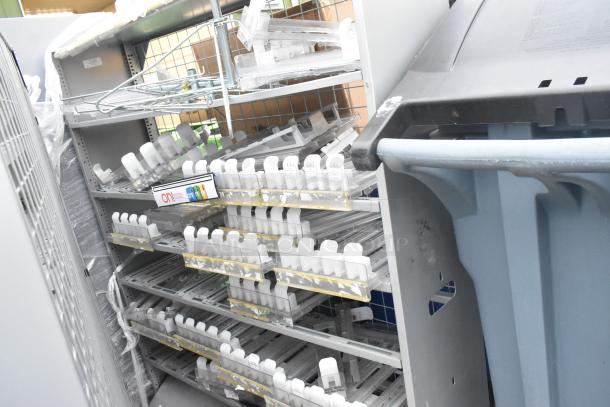 Two gray metal shelving units with multiple wire shelves, containing various organizers and plastic containers, in good condition.