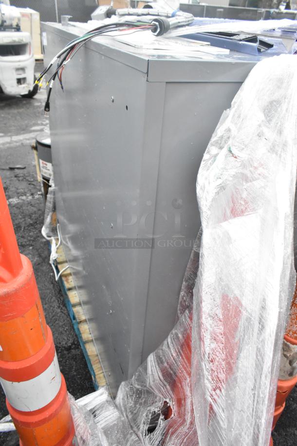 Gray metal shelving unit, new condition, wrapped in plastic on a pallet, includes wiring on top, for auction.