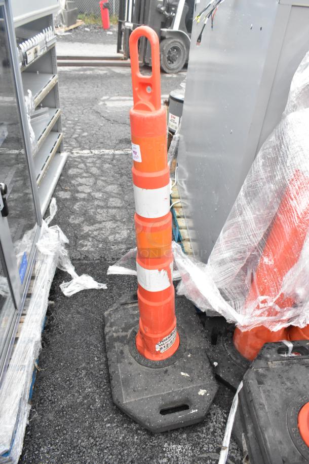 Orange poly cone with reflective stripes on black base, used condition. Includes label with product information.