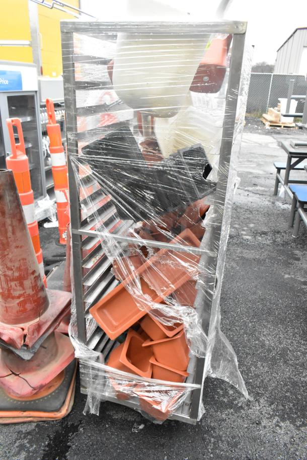 Metal commercial pan transport rack with casters, wrapped in plastic. Contains assorted trays and compartments. Good condition.
