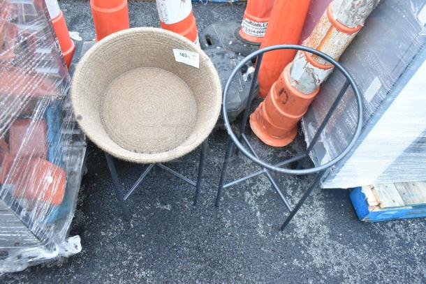 Two black metal stands with a woven basket on one. Includes auction tag "183" indicating quantity of 2.