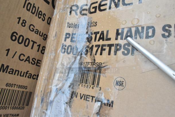 Cardboard box labeled "Regency Pedestal Hand Sink 600T61FTPSP," with water marks and scratches. Box is slightly damaged.