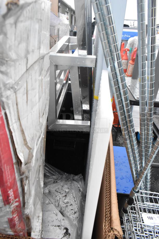 Assorted scratch and dent items, including metal frame and tubing, packaged in a cardboard box.