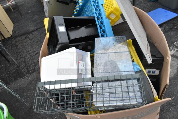 Large cardboard box containing assorted items like storage caddies, plastic bins, and wire baskets. Items appear used.