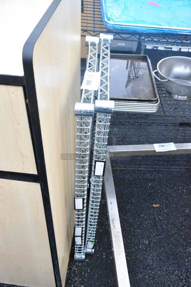 Lot of 2 chrome finish wire shelves, leaning. Each has grid pattern, metal uprights with marked labels, in good condition.