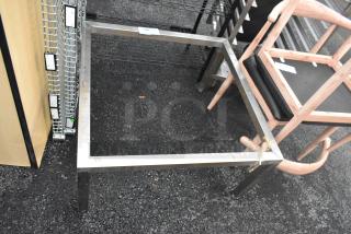 Sturdy metal frame with square design, showing slight wear. Includes a label with numbers. Ideal for furniture projects.