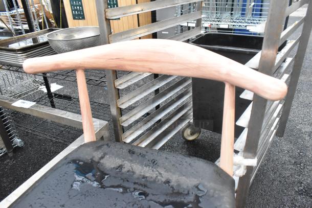 Wooden dining chair with black seat cushion, natural finish, dining height, shown with water stains on seat.