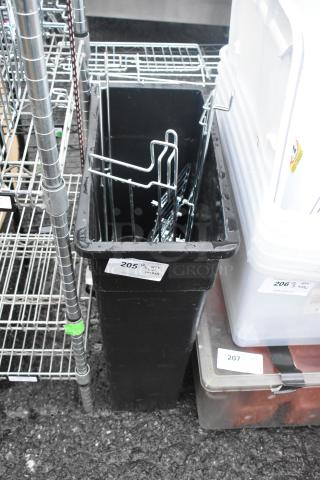 Black Poly Slim Jim trash can containing metal shelving parts, auction tag number 205, in good condition.