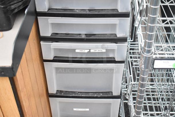 Clear and black poly 7 drawer unit with labeled drawers for organization. Features sturdy construction in good condition. Ideal for storage.